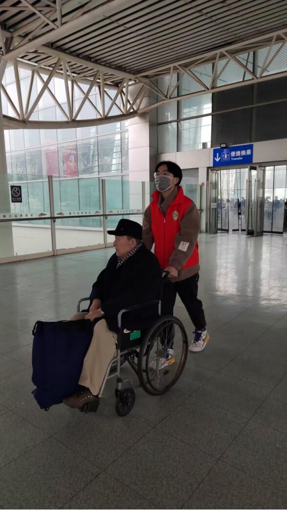 1679895673123781.jpg 图为志愿服务小队成员应宇杨帮助出行困难老人推动轮椅 申英杞 摄.jpg